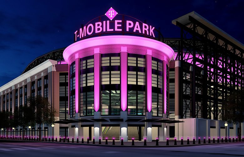 Photo of T-Mobile Park in Seattle, Washington. The stadium is lit up with bright pink accents under a dark night sky.